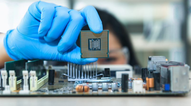 a woman holding computer chip in a laboratory